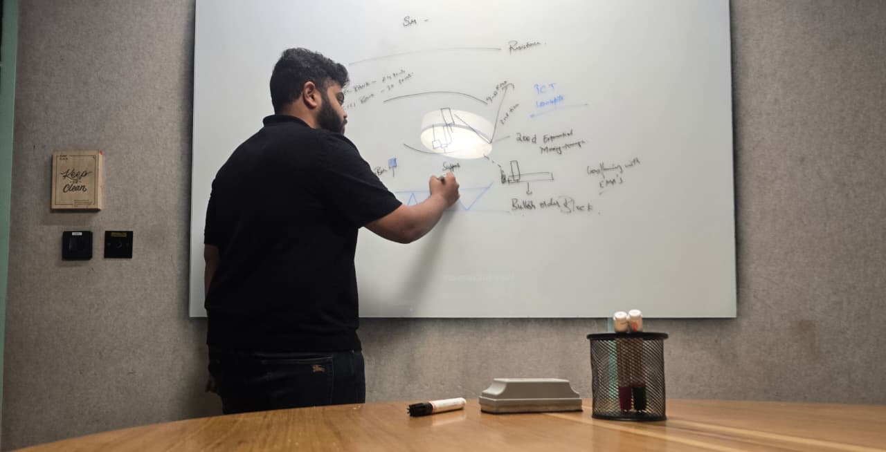 Mentor explaining market concepts on a whiteboard during a live classroom session